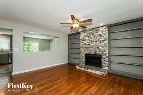 St. Louis house for rent - a living room with a stone fireplace and a ceiling fan