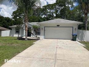 North Port house for rent - a white house with a driveway and a garage door