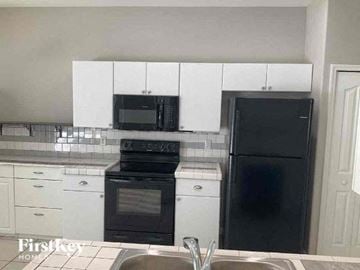 North Port house for rent - a kitchen with a black stove and a refrigerator