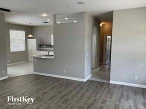North Port house for rent - an empty living room and kitchen with a wood floor