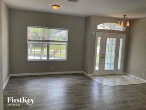 North Port house for rent - an empty living room with a door and a window