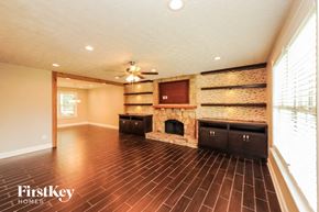 Gainesville house for rent - a living room with a stone fireplace and wooden floors
