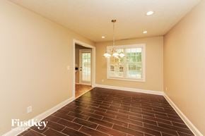 Gainesville house for rent - a empty living room with a chandelier and a window
