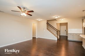 Auburn house for rent - an empty living room with a ceiling fan and a staircase
