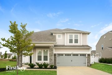 Whitestown house for rent - a house with a garage door in front of a lawn