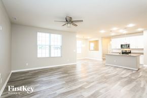 Whitestown house for rent - an empty living room and kitchen with a ceiling fan