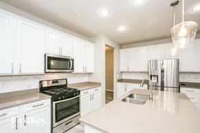 Whitestown house for rent - a white kitchen with stainless steel appliances and white cabinets