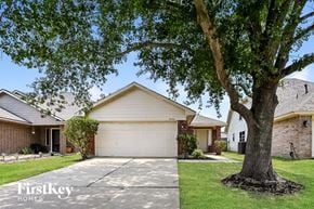 Cypress house for rent - a house with a tree in the yard and a driveway