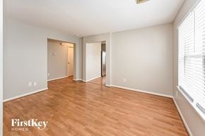Cypress house for rent - an empty living room with wood flooring and a large window
