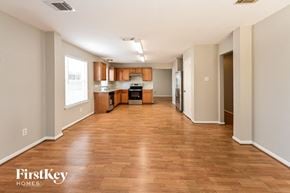 Cypress house for rent - an empty living room and kitchen with wood flooring