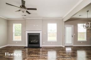 Adairsville house for rent - A modern living room with a fireplace and a ceiling fan.