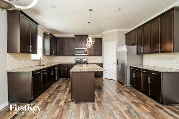 Adairsville house for rent - A kitchen with dark brown cabinets and a wooden floor.