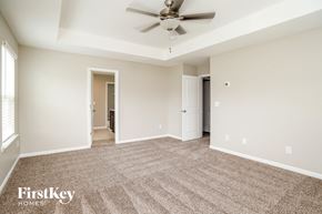 Adairsville house for rent - A spacious room with a carpeted floor and a ceiling fan.