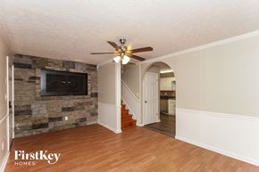 Dallas house for rent - a living room with a stone wall and a ceiling fan