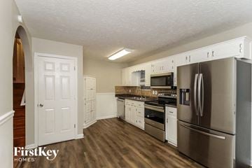 Dallas house for rent - a kitchen with stainless steel appliances and white cabinets