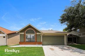 San Antonio house for rent - the front of a house with a driveway and a green garage door