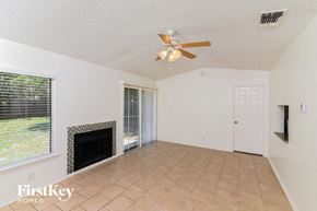 San Antonio house for rent - a living room with a fireplace and a ceiling fan