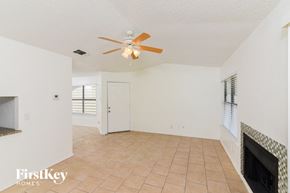 San Antonio house for rent - a living room with a fireplace and a ceiling fan