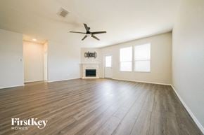 Little Elm house for rent - an empty living room with a ceiling fan and a fireplace