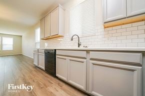 Little Elm house for rent - a white kitchen with white cabinets and a dishwasher in it