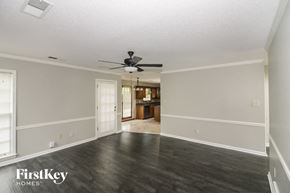 Collierville house for rent - an empty living room with wood floors and a ceiling fan