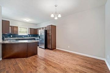Jacksonville house for rent - A kitchen with brown cabinets and a refrigerator.