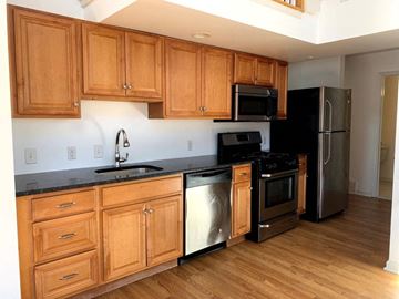 Philadelphia apartment for rent - a kitchen with wooden cabinets and stainless steel appliances