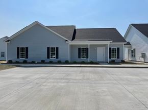 Wilson apartment for rent - A white house with a grey roof and a driveway in front.