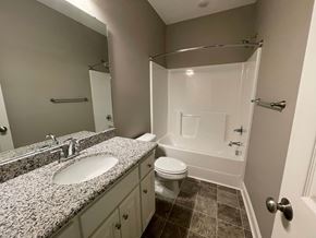 Wilson apartment for rent - A bathroom with a sink, toilet, and bathtub.