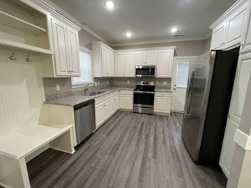 Wilson apartment for rent - A kitchen with white cabinets and a black refrigerator.