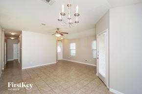 New Braunfels house for rent - A spacious room with a chandelier and a ceiling fan.