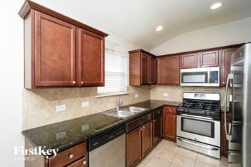 New Braunfels house for rent - A kitchen with brown cabinets and stainless steel appliances.
