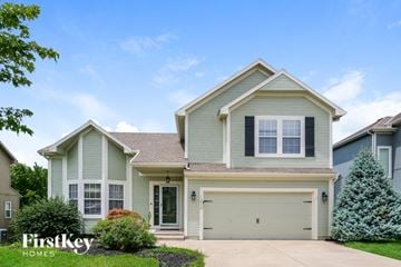 Kansas City house for rent - a beige and green house with a driveway
