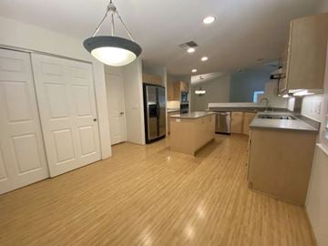 Kapolei apartment for rent - an open kitchen and living room with a wooden floor and a refrigerator