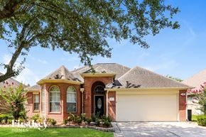 Houston house for rent - A house with a garage and a tree in front.