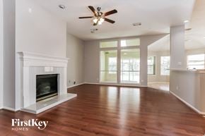 Houston house for rent - A spacious living room with a fireplace and wood flooring.