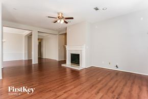 Houston house for rent - A spacious room with a fireplace and wooden flooring.