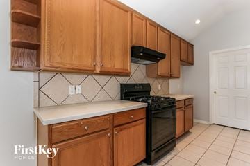 Houston house for rent - A kitchen with wooden cabinets and a black stove top oven.
