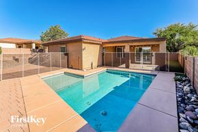 Vail house for rent - A swimming pool in a backyard with a house in the background.