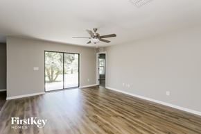 Wimauma house for rent - A spacious room with a ceiling fan and sliding glass doors leading to a patio.