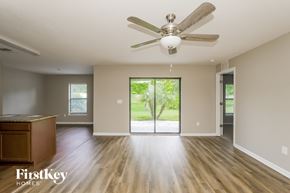 Wimauma house for rent - A spacious room with a ceiling fan and wooden flooring.
