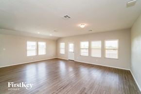 New Braunfels house for rent - A spacious room with wooden floors and white walls.