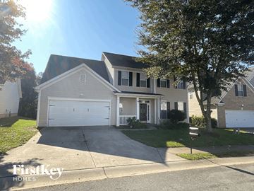 Gastonia house for rent - a white house with a driveway and a white garage door