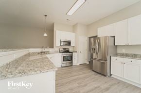 Huntersville house for rent - a kitchen with white cabinets and granite counter tops and stainless steel appliances