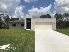 Lehigh Acres house for rent - a house with a garage door and a lawn
