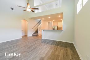 Anahuac house for rent - A spacious room with wooden flooring and a ceiling fan.