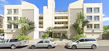 Honolulu apartment for rent - an apartment building with cars parked in front of it