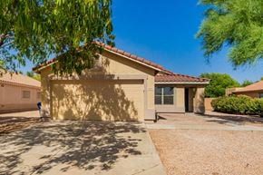 Mesa house for rent - A house with a brown roof and tan walls with a driveway in front.