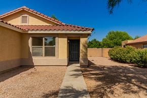 Mesa house for rent - A house with a brown roof and tan walls with a black door and window.