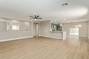 Mesa house for rent - A spacious room with a ceiling fan and lighting fixtures.